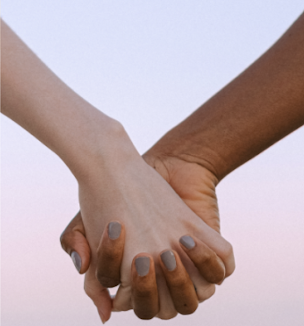 A screenshot of the Emerge Magazine website's home screen with a closeup of two hands with fingers interlocked pictured